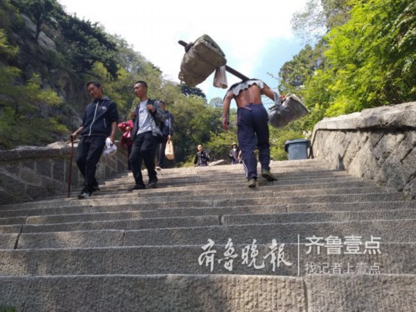 路线五大箱饮料和两大箱面包,重量达一百多斤,一位挑山工师傅从中天门