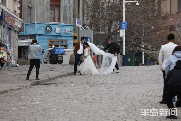 风中：风中的浪漫：青岛肥城路上不少年轻人拍情侣照和婚纱照