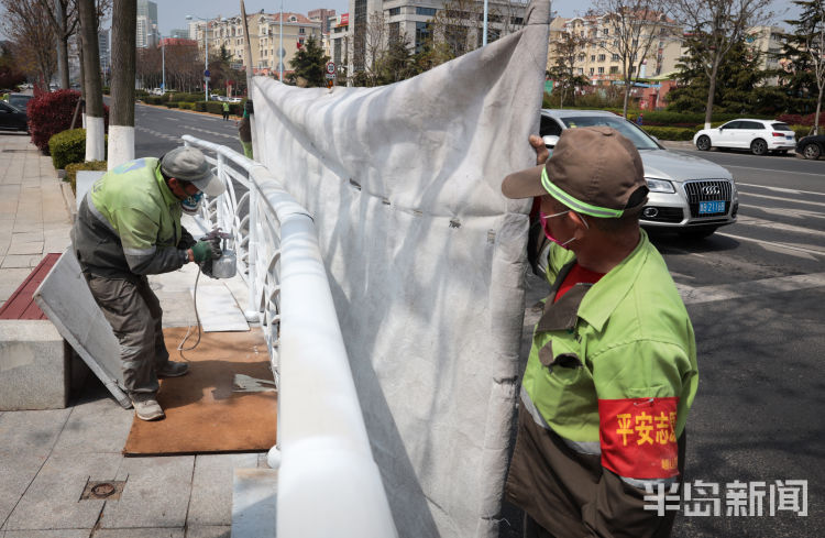 『幕布』崂山去银川东路路边拉起“幕布” 对护栏进行喷漆作业