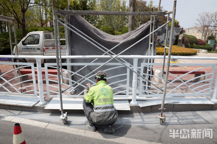 『幕布』崂山去银川东路路边拉起“幕布” 对护栏进行喷漆作业