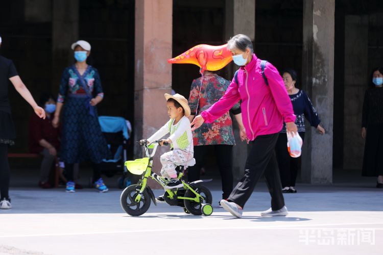 老扶幼青岛市区艳阳高照 不少老人带着孩子享受户外休闲时光