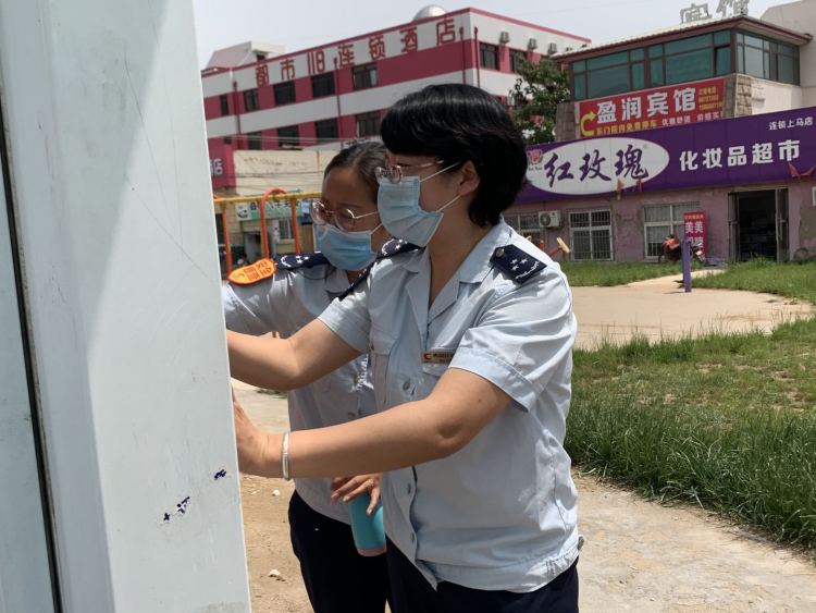 等车城阳巴士120路乘务员清理公交站台小广告 保持干净整洁等车环境