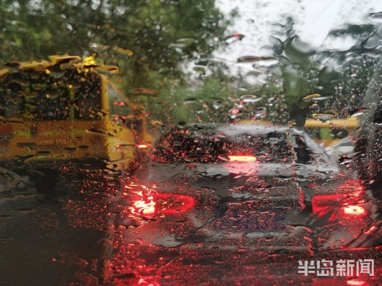 雨中青岛：孩子和家长在雨中赶往学校 下雨天出行请注意安全