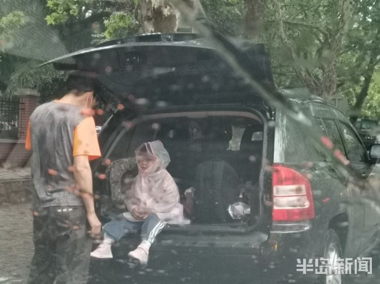 雨中青岛：孩子和家长在雨中赶往学校 下雨天出行请注意安全