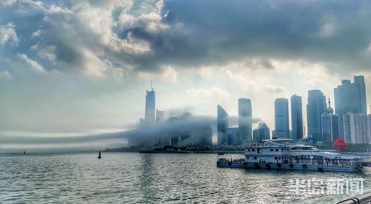 此景雾气飘进市南沿海林立的高楼中 层叠隐现场面震撼