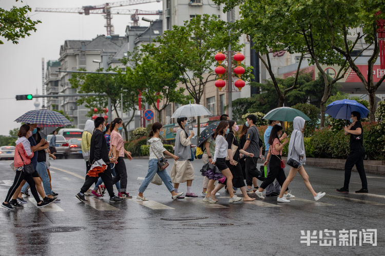 冒雨6月12日青岛飘起阵阵小雨 上班的人们匆匆走在雨中