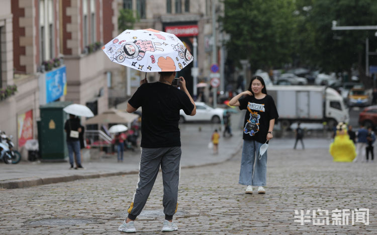 蒙蒙细雨青岛：市民打着雨伞在蒙蒙细雨中拍照