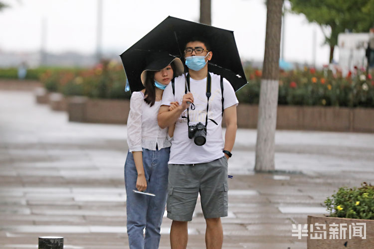 雨中漫步：市南海边游客游览美景
