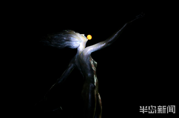 红月红色满月与雕塑园时尚雕塑相映成景 吸引路人驻足观看