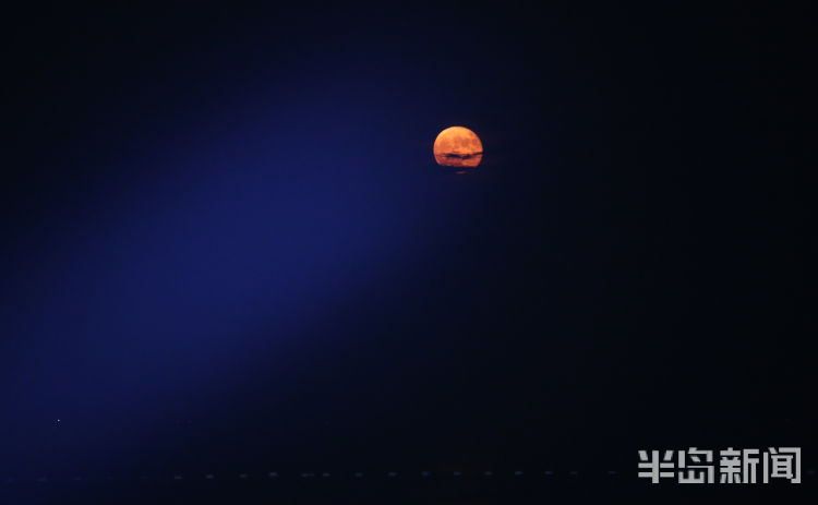 红月红色满月与雕塑园时尚雕塑相映成景 吸引路人驻足观看