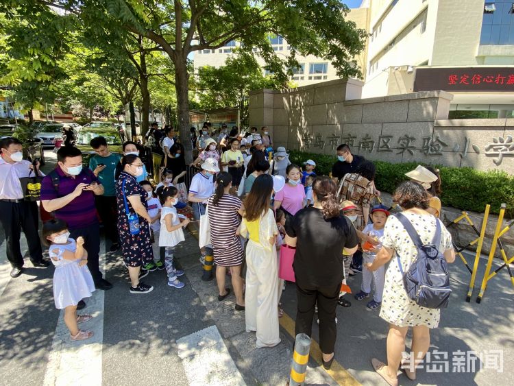 测体温|青岛小学新生报名现场确 抽号、测体温、出示健康码一项都不能少