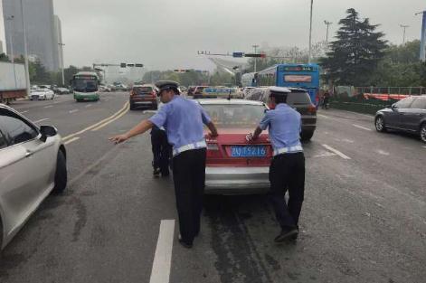 趴窝|出租车“趴窝”堵路 青岛交警高温下徒手推车