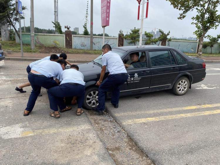 凹沟|城阳巴士二分公司：轿车车轮陷进凹沟 公交驾驶员齐力抬出