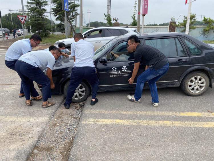 凹沟|城阳巴士二分公司：轿车车轮陷进凹沟 公交驾驶员齐力抬出