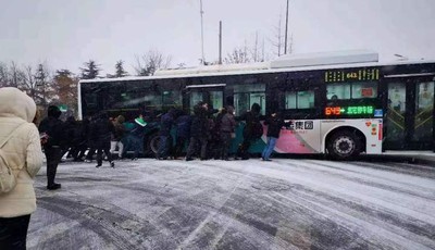 天寒人心暖！降雪天青岛一公交车打滑 数十人推车团结力量大