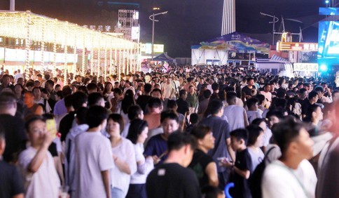 夜幕降临，金沙滩啤酒城光影璀璨游客如潮