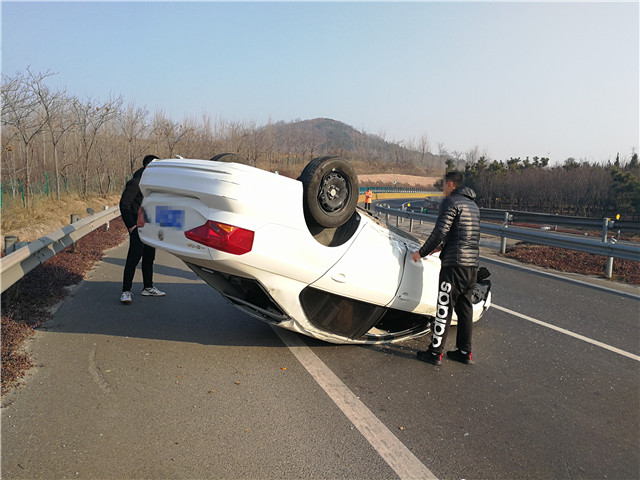 行车时操作不当小轿车倒翻高速公路