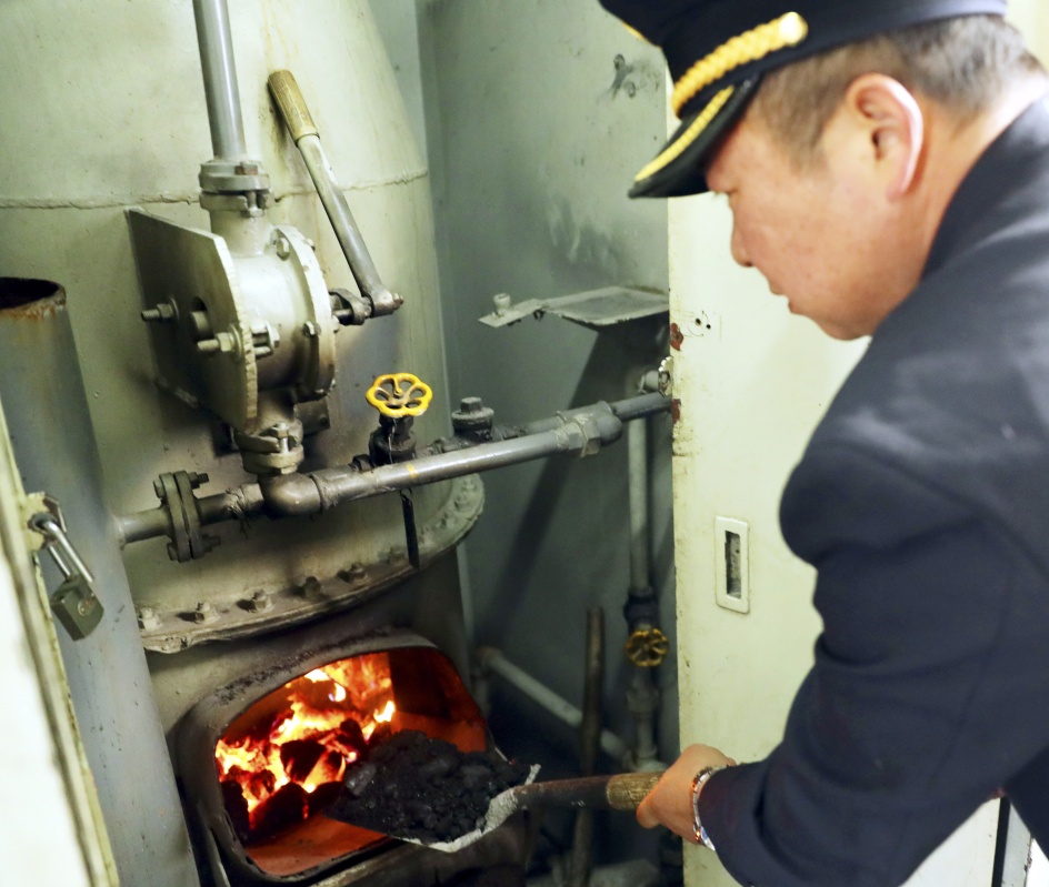 1月4日,在太原开往石家庄北的6034次列车上,列车员在给茶炉添煤.