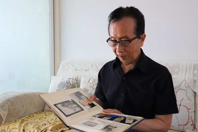张维镇老人正在看自己收藏的商标图集.
