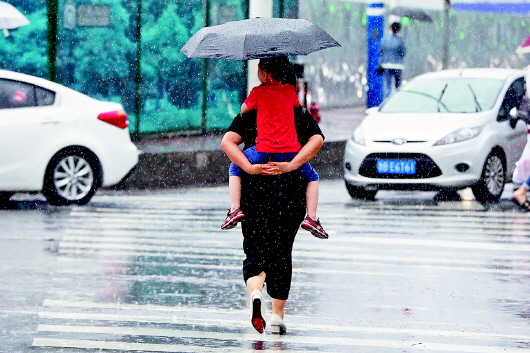 路上不少家长撑起伞为孩子挡雨,有的则干脆把孩子背起来.