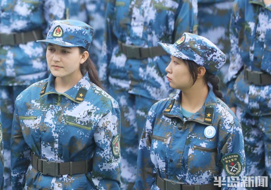 练习军姿的女生.刚入学的大一女生穿上迷彩服参加军训.