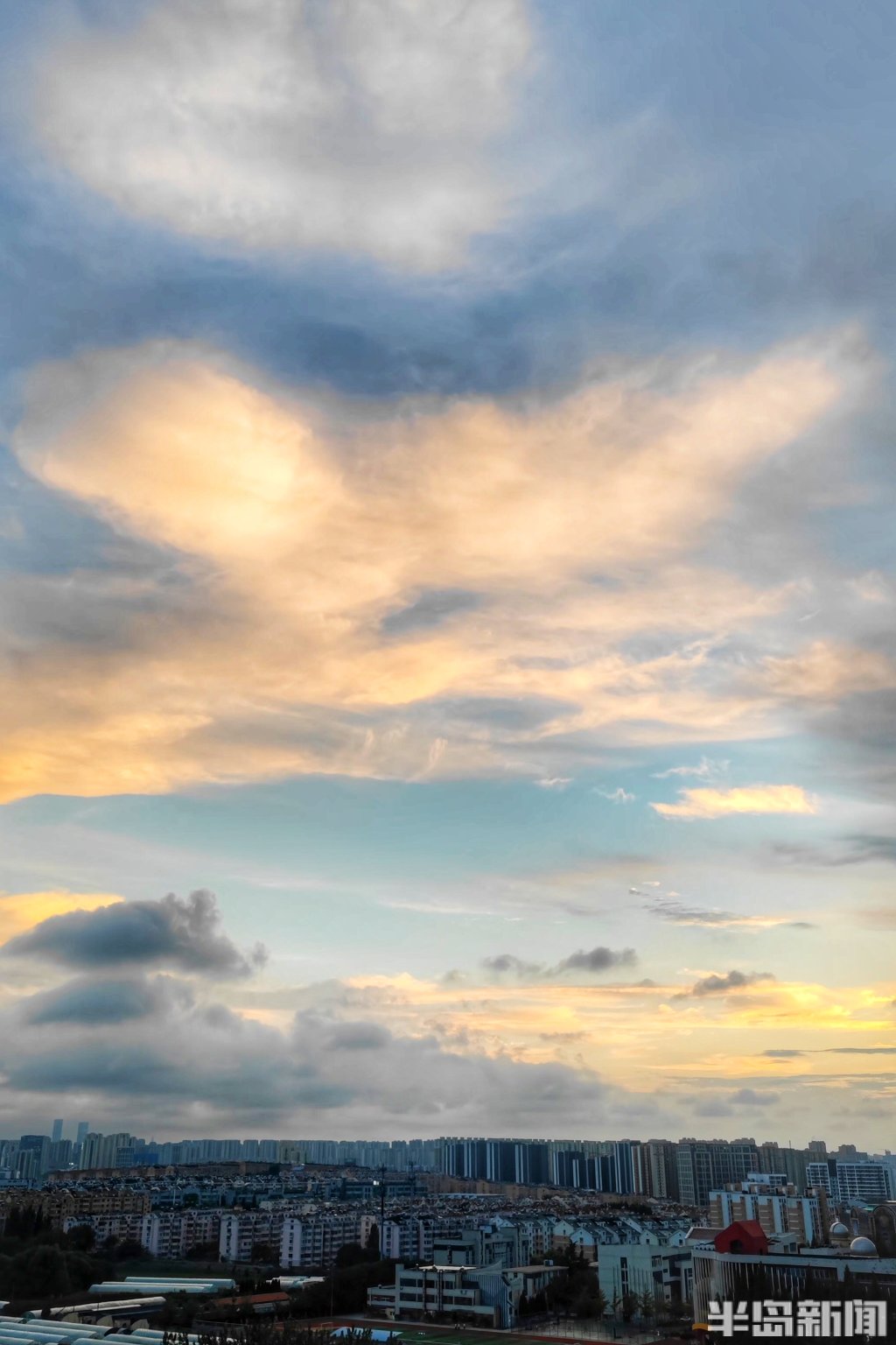 9月18日傍晚,青岛夕阳西下,恰逢阴云变得稀薄,阳光斜照在云层上,将